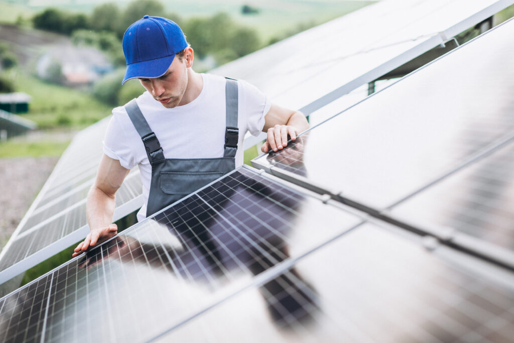 Man worker in the firld by the solar panels